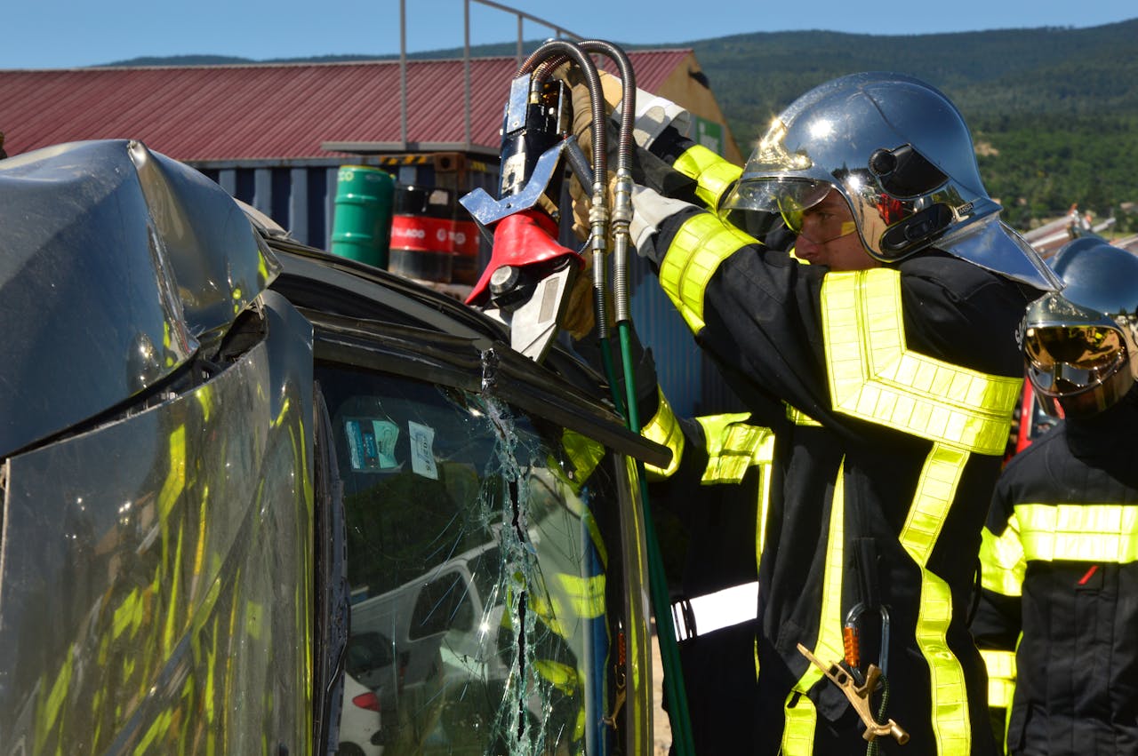 services-02 Firefighters in action using rescue tools at a car accident scene outdoors.